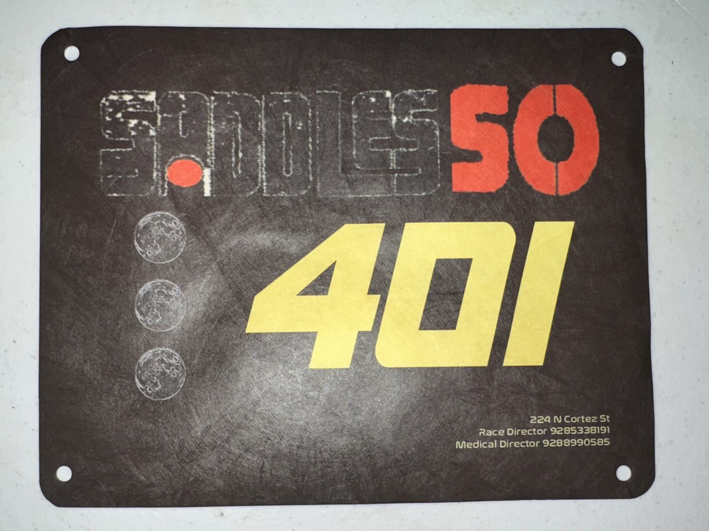A Saddles 50 bib, number 401: distressed lockup, three moon phases, the race's italic numerals